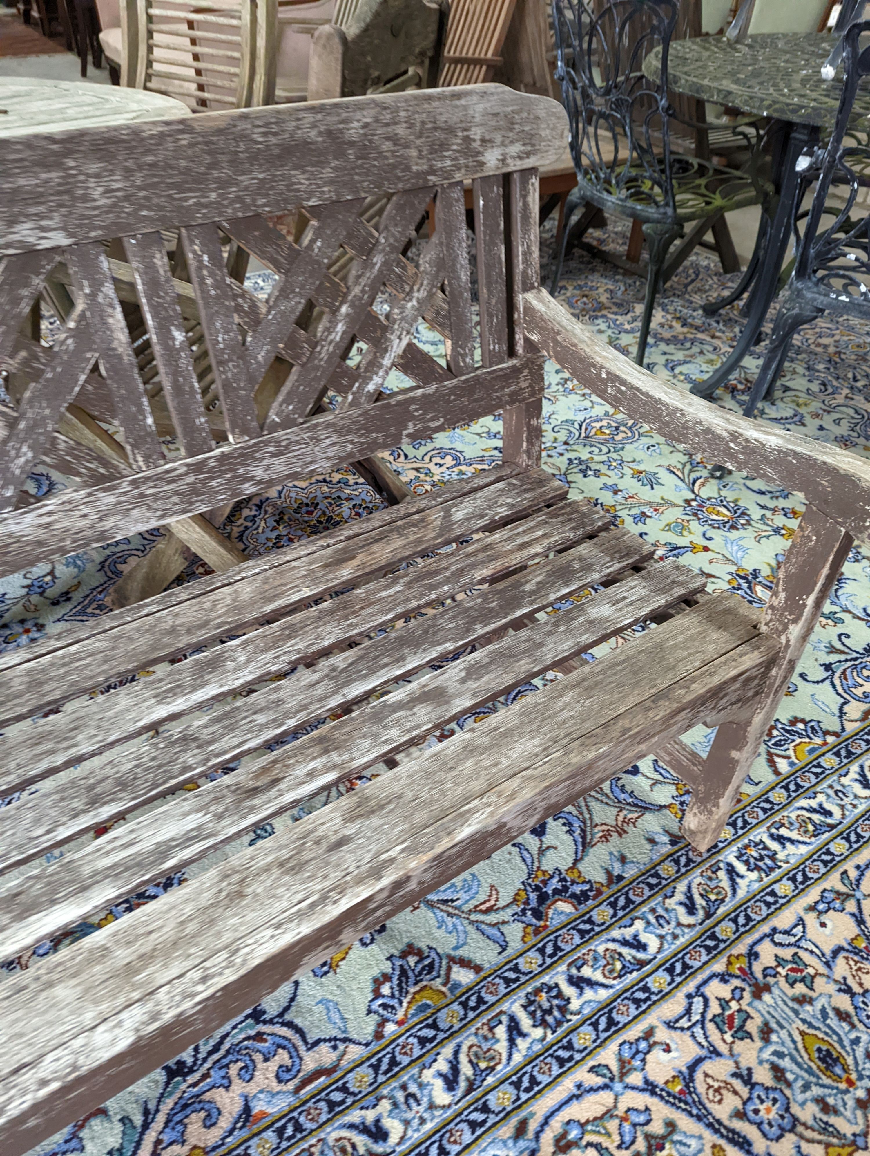 A weathered teak garden bench, length 146cm, depth 50cm, height 86cm